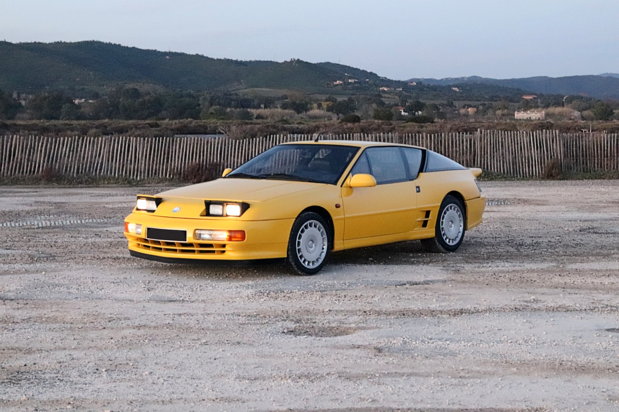 Alpine A610 youngtimer phares escamotables allumés au crépuscule