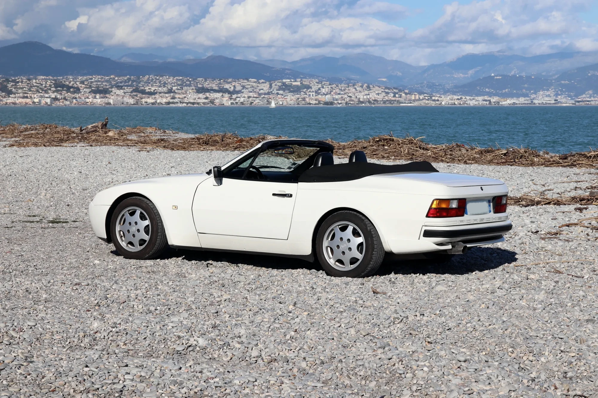 Porsche 944 S2 Cabriolet blanche capote baissée face à la mer