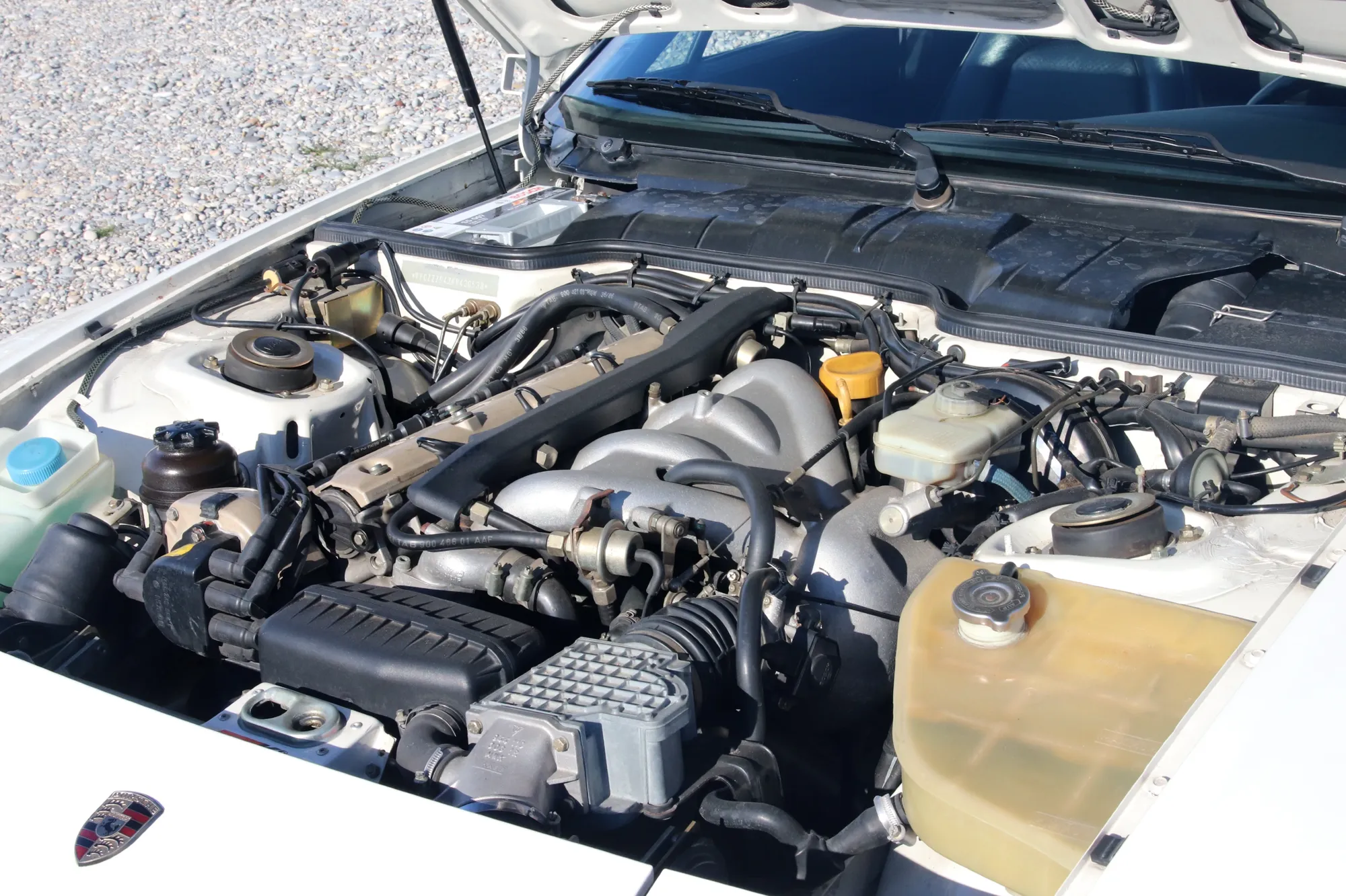 Moteur Porsche 944 vue de face sous le capot, faisceaux et durites apparents