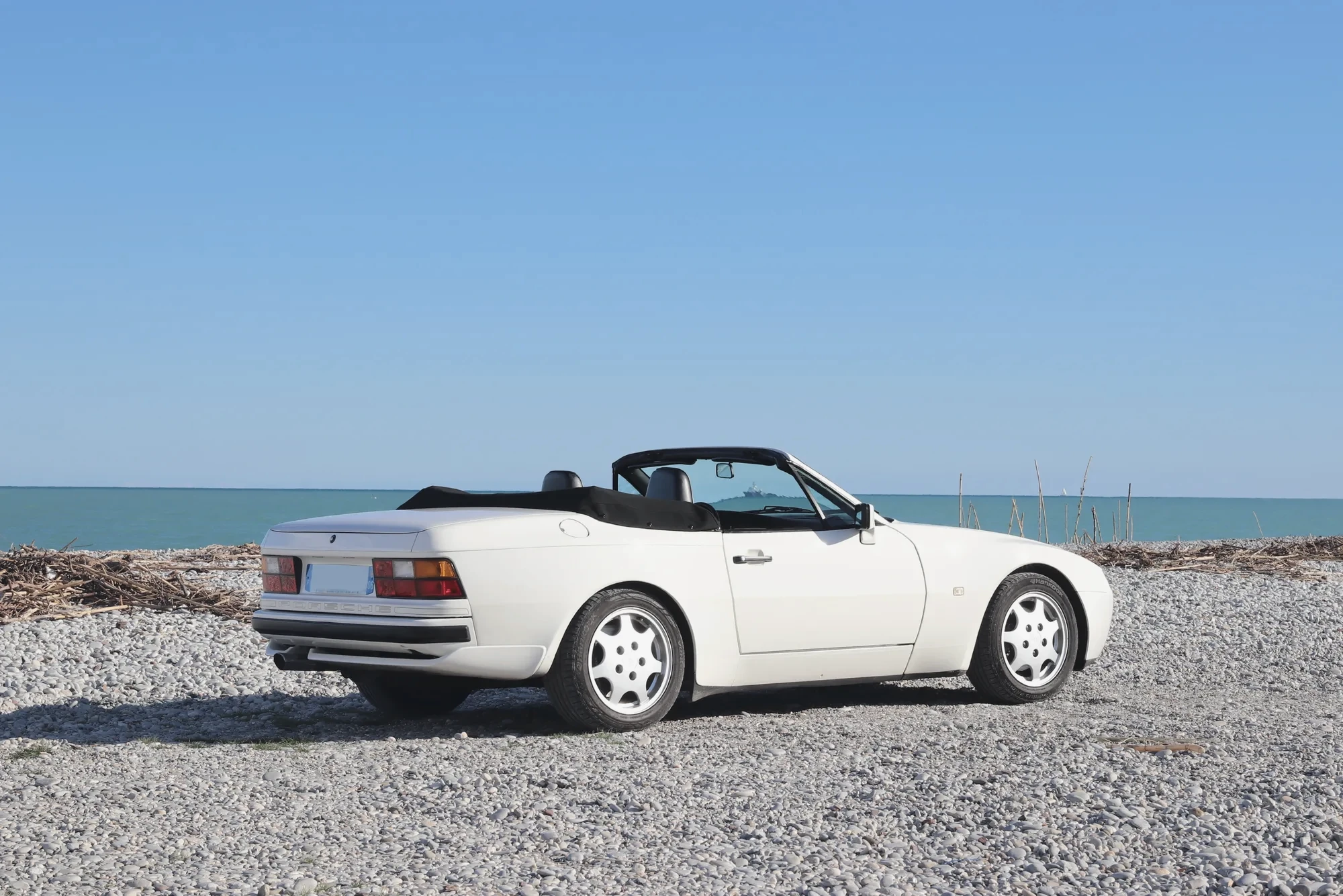 Porsche 944 cabriolet vue arrière trois-quarts face à la mer