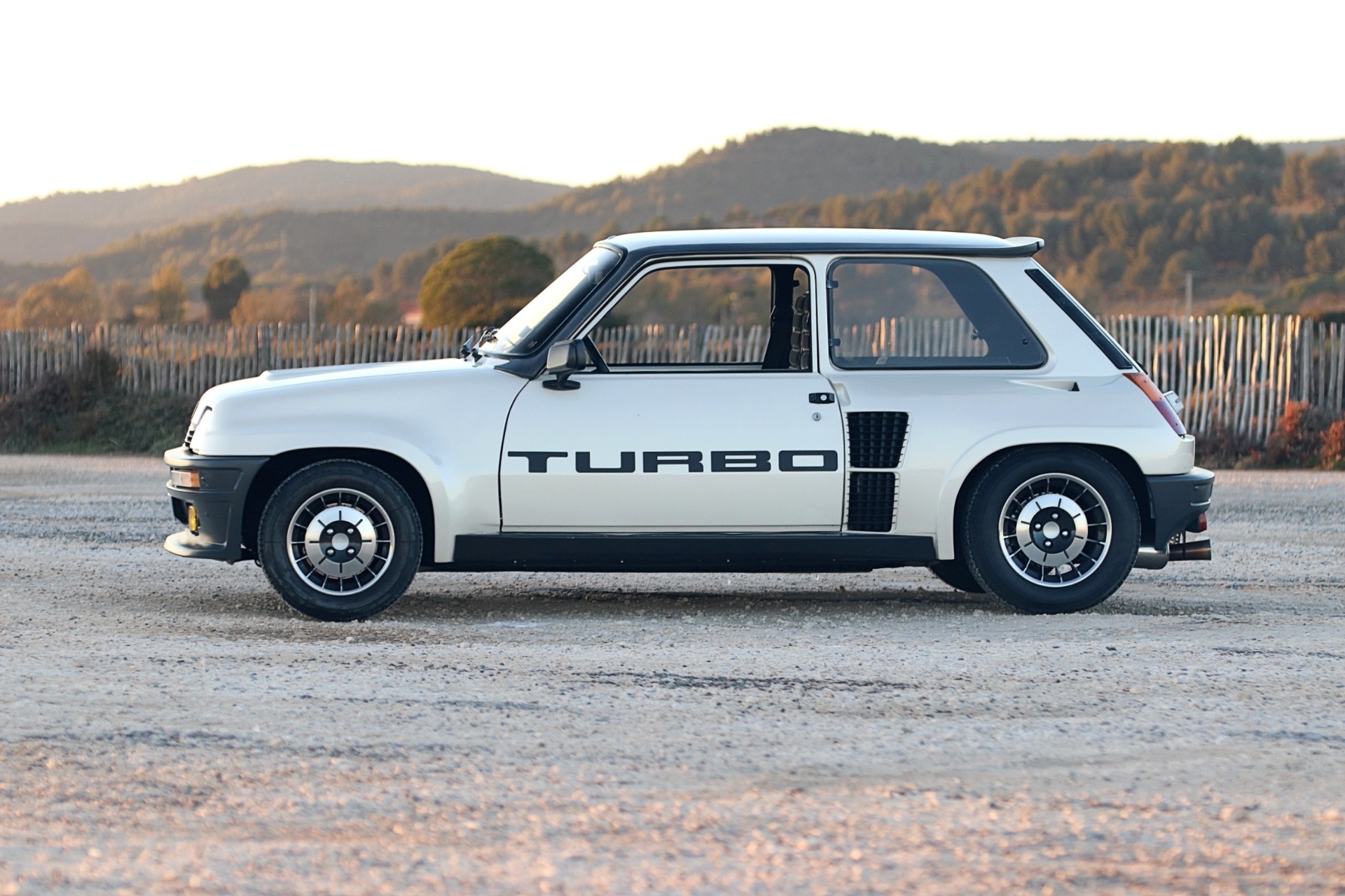 Renault 5 Turbo blanche de profil au coucher du soleil